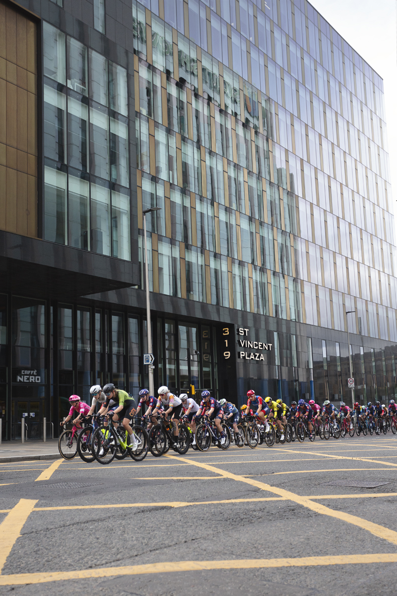 Tour of Britain Women’s 2025 - Stage 4 - The peloton races past the glass structure of St Vincent Plaza