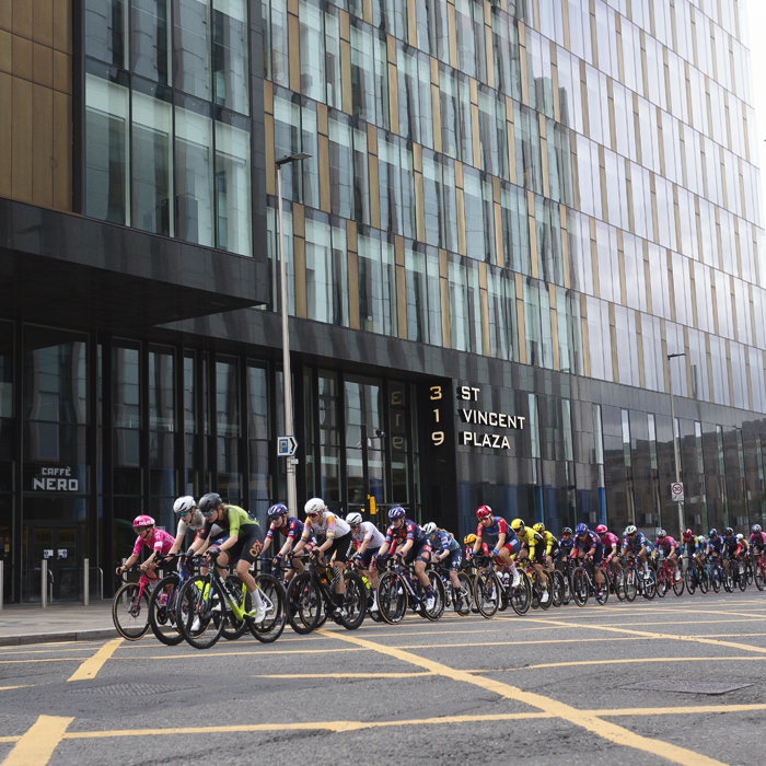 Tour of Britain Women’s 2025 - Stage 4 - The peloton races past the glass structure of St Vincent Plaza