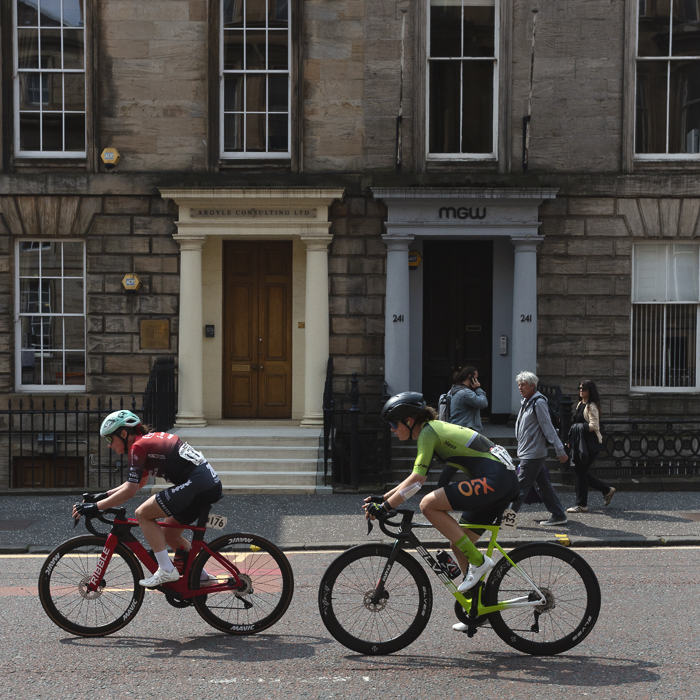 Tour of Britain Women’s 2025 - Stage 4 - Jo Tindley & Holly Ramsey pass two stone buildings with grand entrances