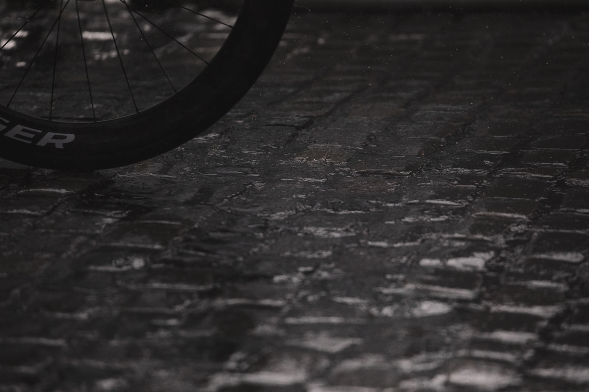 Tour of Britain Women’s 2025 - Stage 3 - A rider’s wheel on the wet cobbles at the end of the stage in Kelso