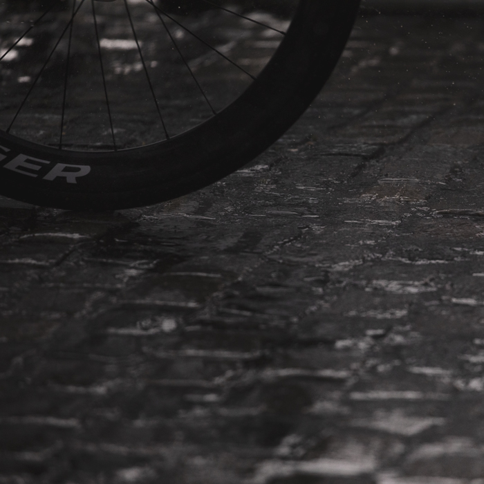 Tour of Britain Women’s 2025 - Stage 3 - A rider’s wheel on the wet cobbles at the end of the stage in Kelso