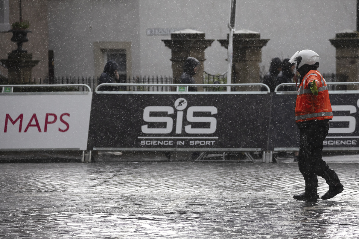 Tour of Britain Women’s 2025 - Stage 3 - Race staff direct vehicles to the deviation point in the pouring rain at Kelso