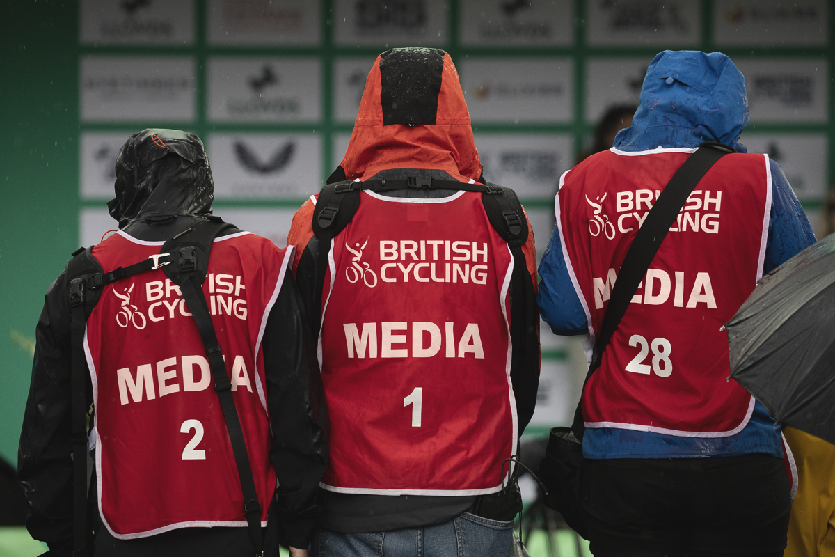 Tour of Britain Women’s 2025 - Stage 3 - Sodden photographers stand on a raised flower bed in Kelso
