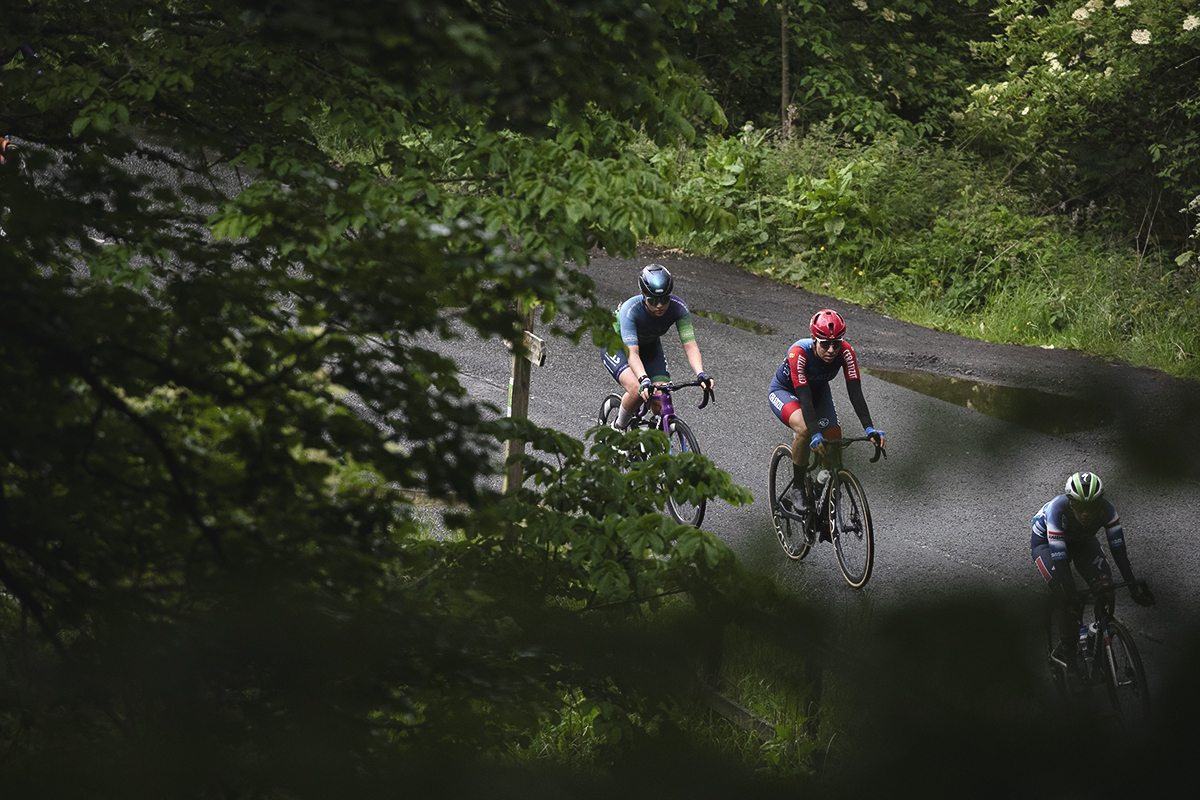 Tour of Britain Women’s 2025 - Stage 3 - Riders framed by trees at Leaderfoot