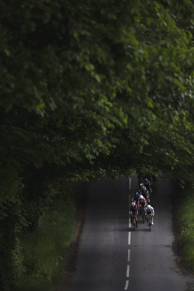 Tour of Britain Women’s 2025 - Stage 3 - Riders in a patch of light in the trees in Lillisleaf