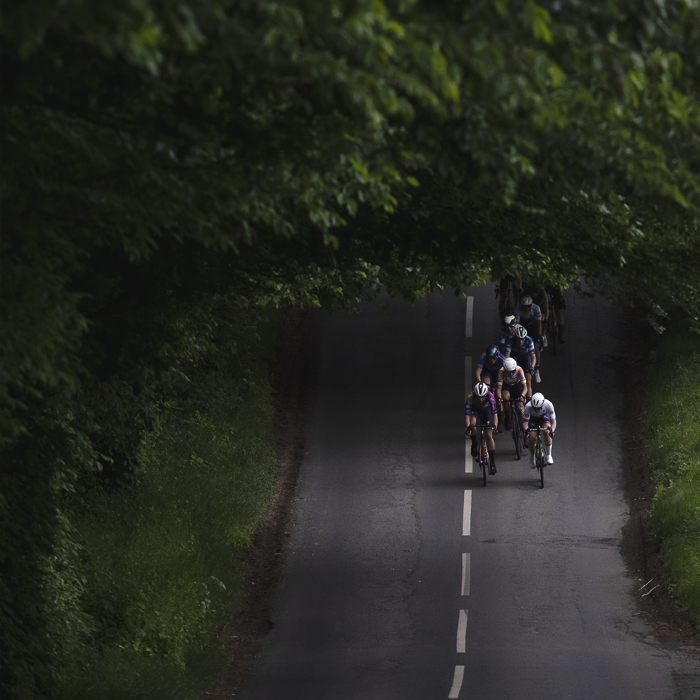 Tour of Britain Women’s 2025 - Stage 3 - Riders in a patch of light in the trees in Lillisleaf