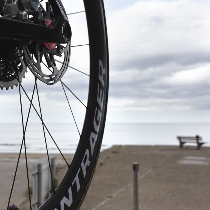 Tour of Britain Women’s 2025 - Stage 1 - The seafront at Redcar with a bike wheel in the foreground