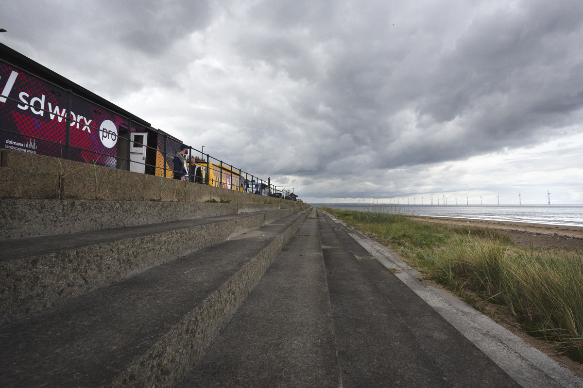 Tour of Britain Women’s 2025 - Stage 1 - Team buses line the seafront in Redcar with the steps down to the beach in the foreground