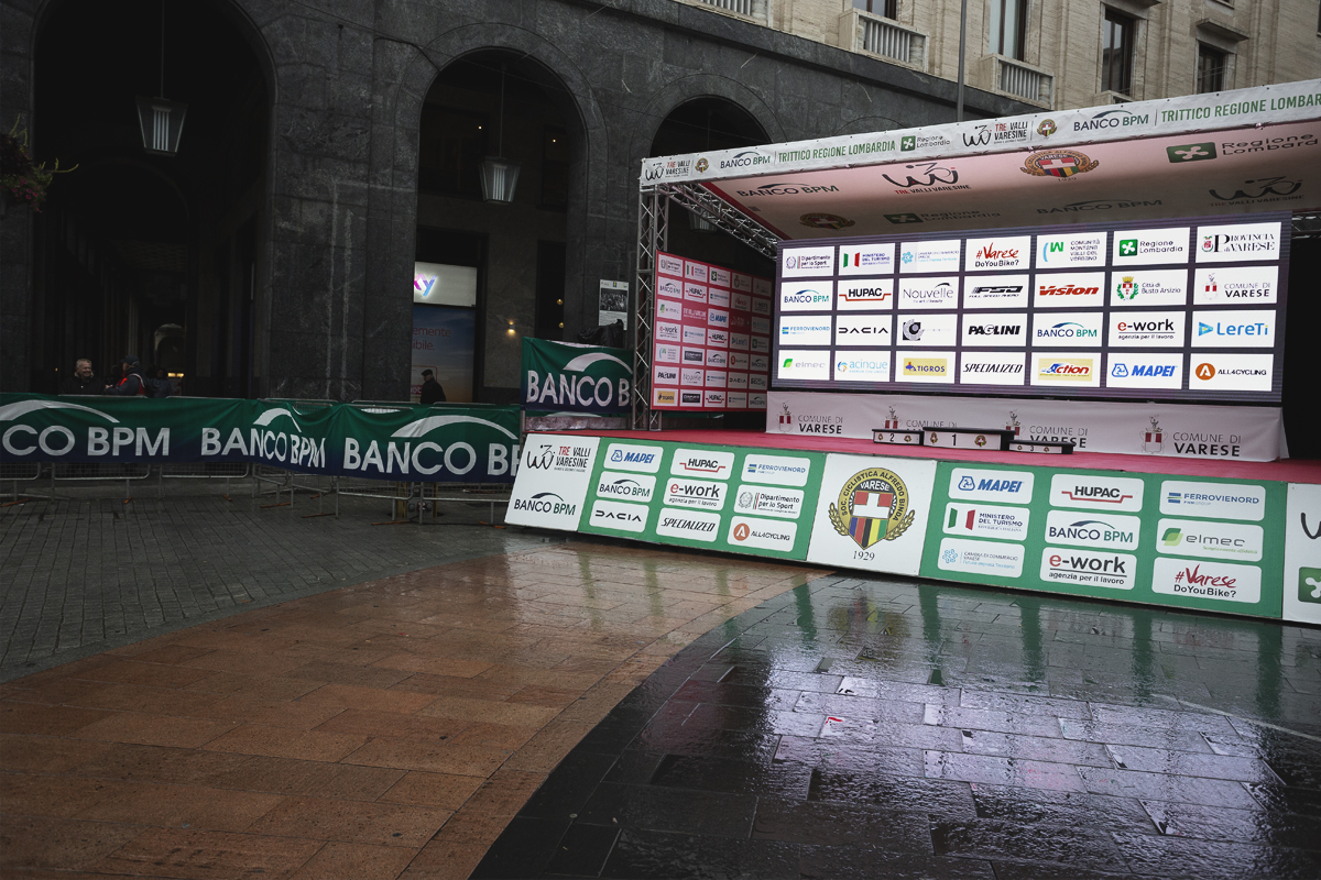 Tre Valli Varesine 2024 - The empty podium reflects in the puddles following the abandonment of the race