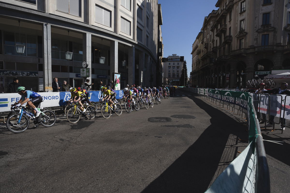 Tre Valli Varesine 2025 - Riders pass by commercial buildings in Varese