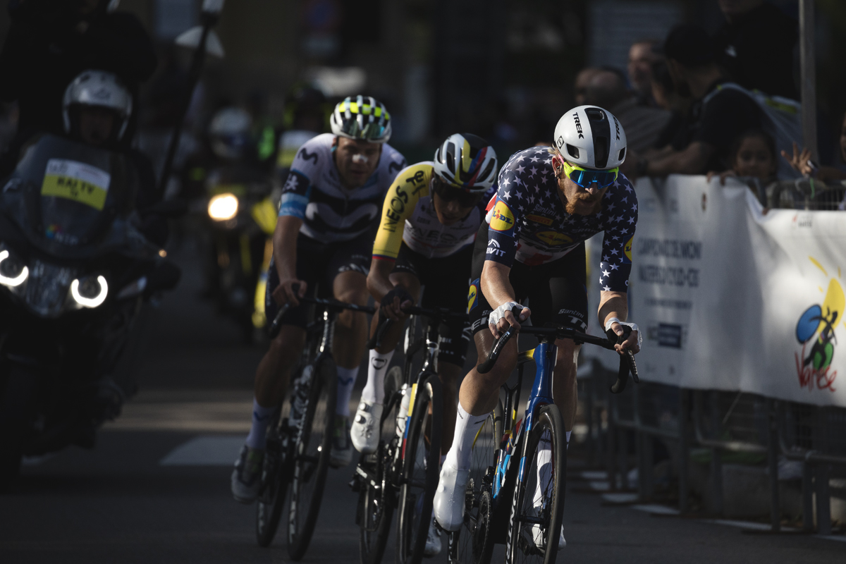Tre Valli Varesine 2025 - Quinn Simmons is lit by late afternoon sunlight as he leads a group of riders