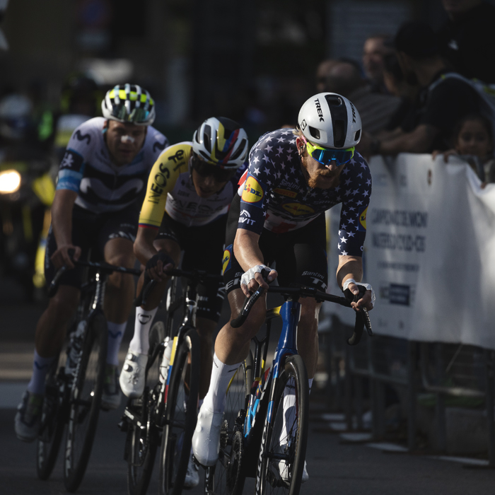 Tre Valli Varesine 2025 - Quinn Simmons is lit by late afternoon sunlight as he leads a group of riders