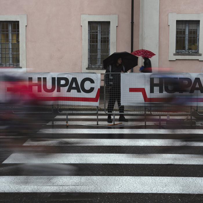 Tre Valli Varesine Women’s Race 2024 - Spectators sheltering under umbrellas watch the riders come into the finish