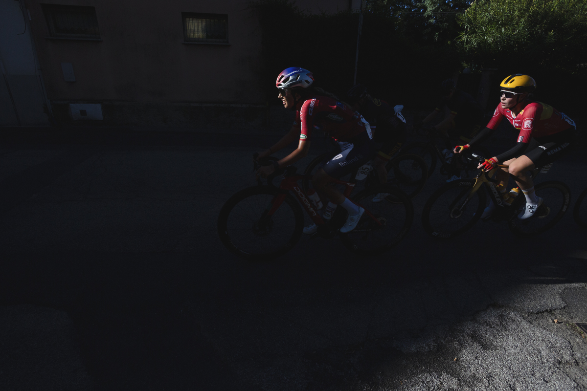 Tre Valli Varesine Women’s Race 2025 - Riders emerge from deep shadows their faces caught by bright sunlight