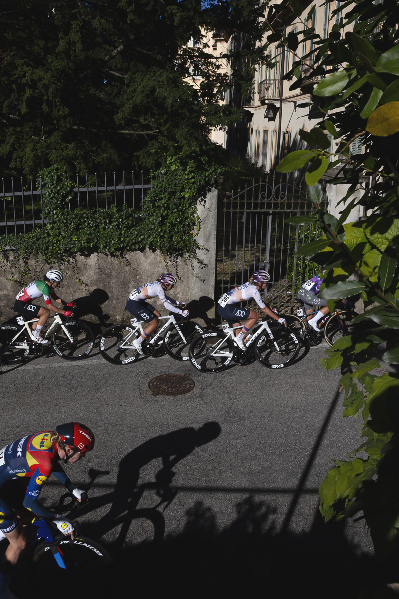 Tre Valli Varesine Women’s Race 2025 - Riders seen from an elevated position as they pass by wrought iron gates covered in ivy