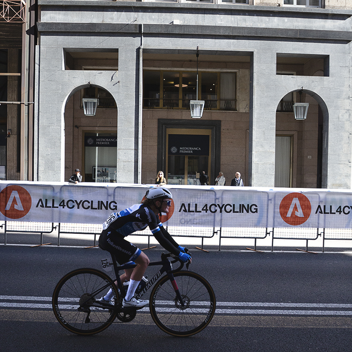 Tre Valli Varesine Women’s Race 2025 - A smiling Malou Eisen rides past shops in the arcades of Varese