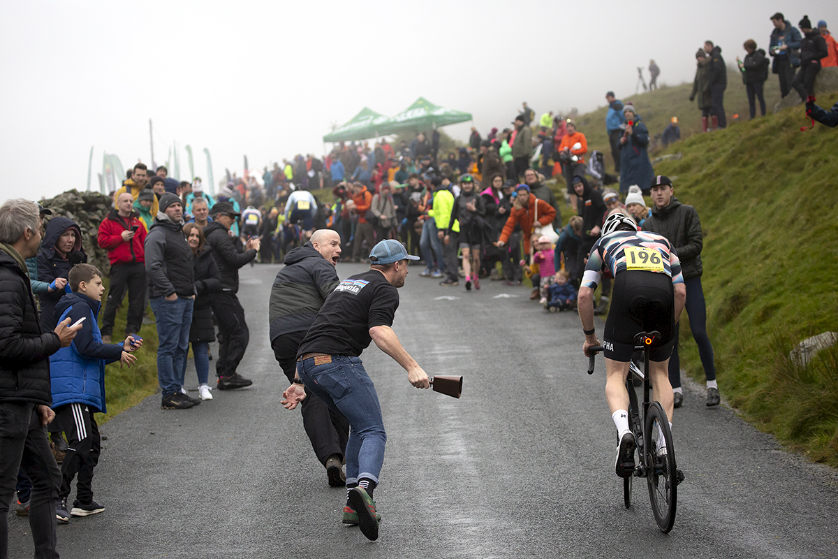 UK National Hill Climb Championships 2023 - Throngs of supporters line the roads as Sean Nicholls is encouraged by tow fans running alongside him