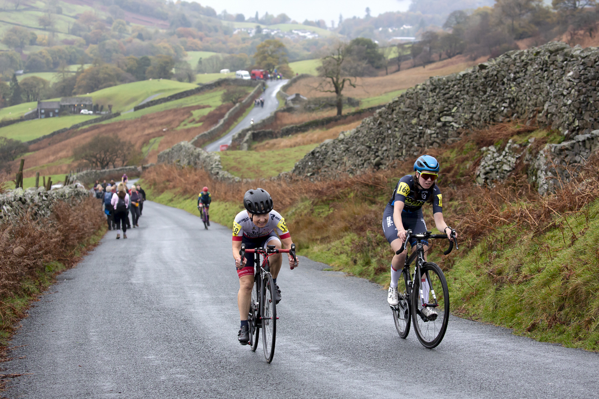 UK National Hill Climb Championships 2023 - Wiebke Rietz & Lilja Raine make their way up The Struggle with the road winding through the countryside in the background